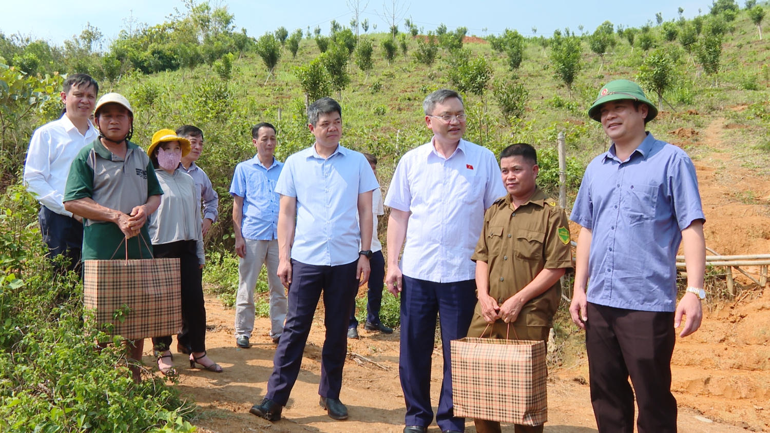 Đồng chí Quàng Văn Hương Phó Chủ tịch Hội đồng Dân tộc tặng quà cho 2 hộ dân trồng mắc ca bản Cang